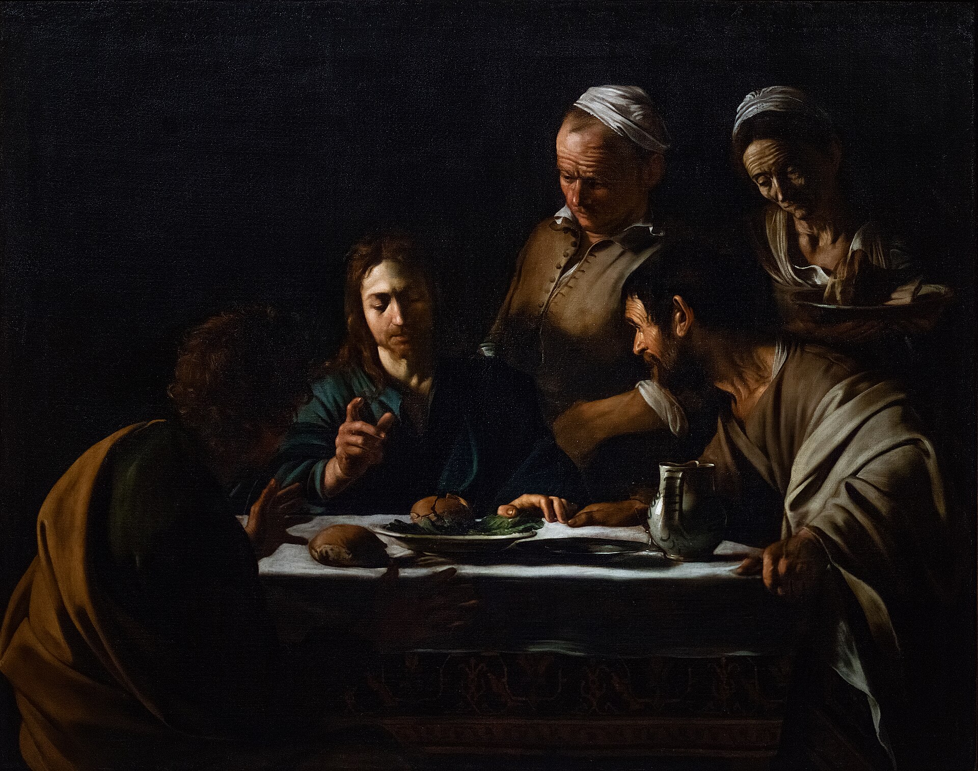 Jesus blesses bread at a dimly lit table with the disciples at Emmaus in Caravaggio’s 1606 painting.